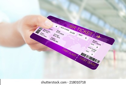 first class fly ticket holded by hand. focus on ticket