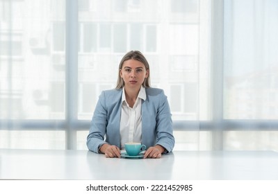 But First Coffee. Young Tired Business Woman In Formal Wear Sitting In The Office At Empty Desk With Cup Of Coffee. Female White Collar Worker, Freelancer Financial Expert Morning Routine.