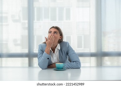 But First Coffee. Young Tired Business Woman In Formal Wear Sitting In The Office At Empty Desk With Cup Of Coffee. Female White Collar Worker, Freelancer Financial Expert Morning Routine.