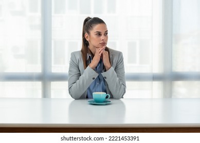 But First Coffee. Young Tired Business Woman In Formal Wear Sitting In The Office At Empty Desk With Cup Of Coffee. Female White Collar Worker, Freelancer Financial Expert Morning Routine.