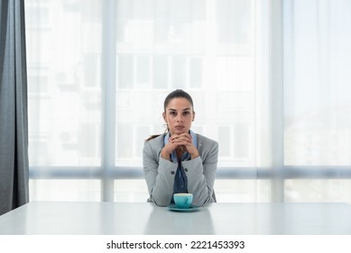 But First Coffee. Young Tired Business Woman In Formal Wear Sitting In The Office At Empty Desk With Cup Of Coffee. Female White Collar Worker, Freelancer Financial Expert Morning Routine.