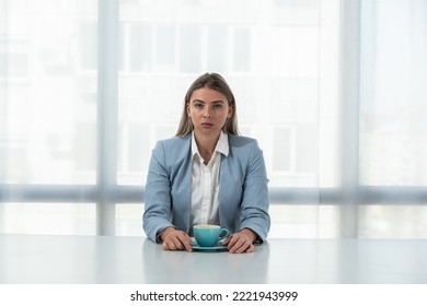 But First Coffee. Young Unhappy Tired Business Woman In Formal Wear Sitting In The Office At Empty Desk With Cup Of Coffee. Female White Collar Worker, Freelancer Financial Expert Morning Routine.