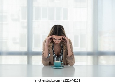 But First Coffee. Young Unhappy Tired Business Woman In Formal Wear Sitting In The Office At Empty Desk With Cup Of Coffee. Female White Collar Worker, Freelancer Financial Expert Morning Routine.