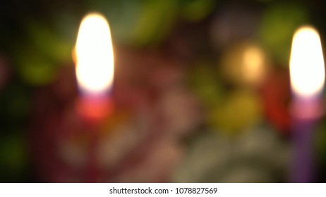 The First Day Of The Jewish Holiday Of Hanukkah. Two Candles Are Burning On Flower Colorful Background. Blurred View,