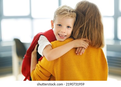 First day at school.  Cheerful child   schoolboy   hugs his mother before the first day at school at home - Powered by Shutterstock