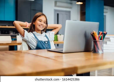First day at school. Cute and happy little girl children using laptop computer, studying through online e-learning system. - Shutterstock ID 1614425386
