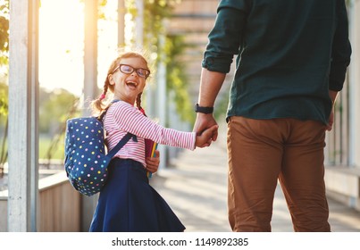 First Day At School. Father Leads A Little Child School Girl In First Grade
