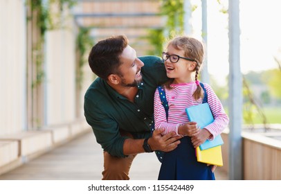 first day at school. father leads a little child school girl in first grade - Shutterstock ID 1155424489