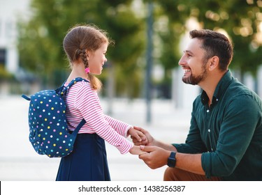 First Day At School. Father Leads A Little Child School Girl In First Grade
