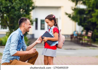 First Day At School. Father Leads A Little Child School Girl In First Grade