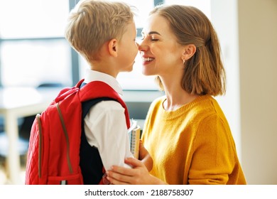 First day at school. Mother adjusts the briefcase to her happy son  during the  preparing   for school studies  at home - Shutterstock ID 2188758307