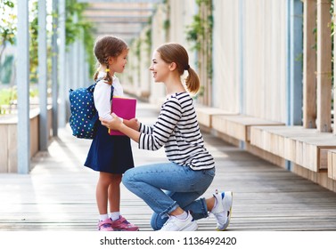 First Day At School. Mother Leads A Little Child School Girl In First Grade

