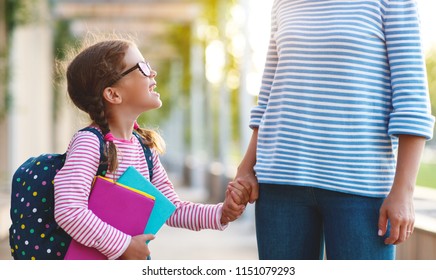 first day at school. mother leads a little child school girl in first grade - Shutterstock ID 1151079293