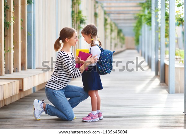first day at school. mother leads a little child
school girl in first
grade

