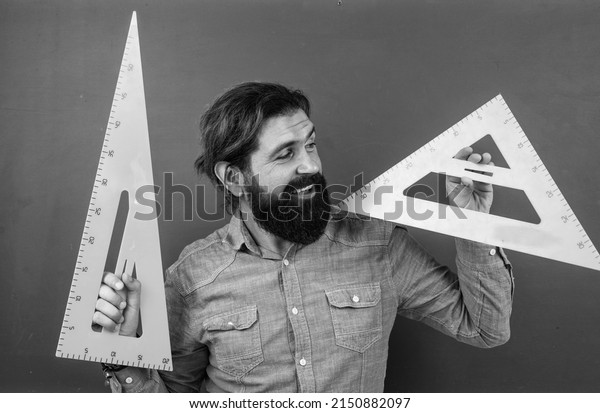 First day of school. pass the math exam. learning\
the subject. cheerful man with beard using triangle ruler. studying\
the measurement. formal education. male student at mathematics\
school lesson