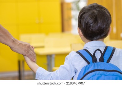 First Day At School Preschool Kid Holding Mother Grandmother Or Teacher Hand.woman Leads Child To His School Desk.yellow Furniture.scared Worried Boy Eyes Looking Up At Teacher.first Grade Back To