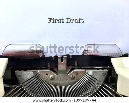 First Draft, author’s manuscript title heading typed on white paper on vintage manual typewriter machine