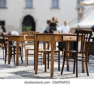 First Floor With Table And Chairs In A Historic Square In Central Italy, Perspective View, Blurred Background