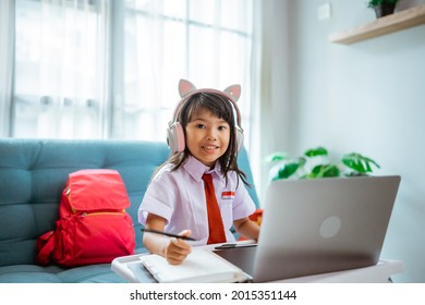 First Grade School Student With Uniform During Online Class Study With Teacher At Home