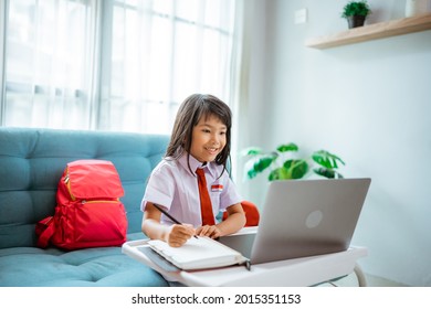first grade school student with uniform during online class study with teacher at home - Shutterstock ID 2015351153