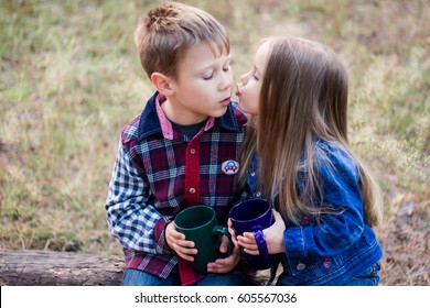 First kiss. Little boy and little girl kissing in the forest