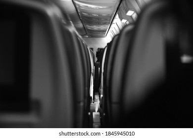 A First Person Perspective Of An Aisle Of Seats On A Commercial Airliner.