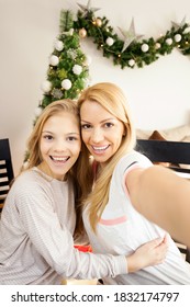 First Person Perspective Of Beautiful Blond-haired Caucasian Mother And Daughter Taking A Selfie In Front Of A Decorated Christmas Tree