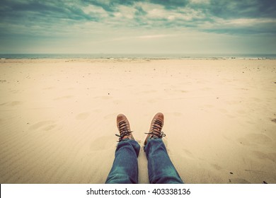 First Person Perspective Of Man Legs In Jeans On The Autumn Beach. Vintage, Retro Style