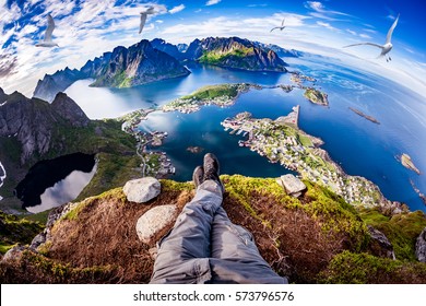 First person perspective shot from a hiker sitting at the edge of a cliff at Lofoten is an archipelago in the county of Nordland, Norway. Fisheye lens.