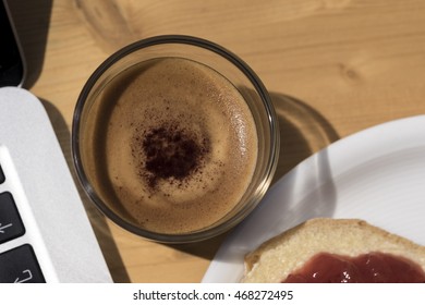 First Person Perspective Top Down View On Dark Foamy Beverage In Glass Beside Toast And Laptop