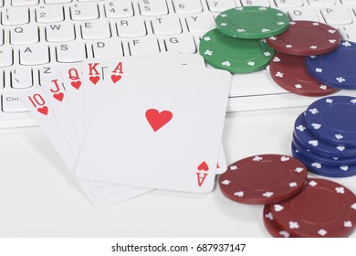 First Person Perspective View On Piles Of Playing Cards And Poker Chips On Keyboard For Concept About Internet Gambling