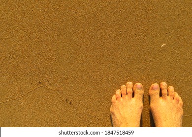 First person shots of feet in the sand with a copy space. Walking along the seaside.