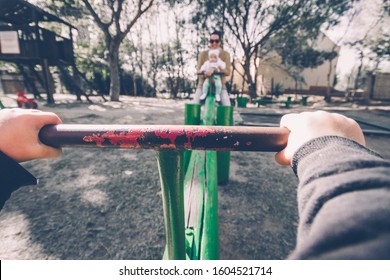 First Person View Of Child On A Seesaw At Playground With Family