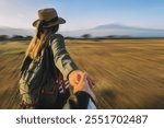 first person view of happy attractive woman her standing on background Kilimanjaro volcano and the African savannah. Woman is holding someone hand. Traveling and follow me. motion blur effect