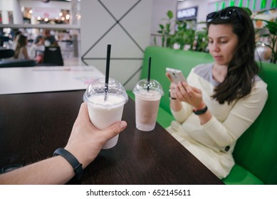 First Person View Look At Woman That Searfing On The Phone In Cafe With Smoothie On The Table