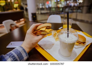 first person view man eat hamburger in cafe first person view