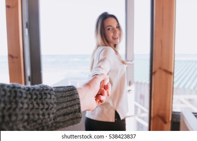 First Person View Of Man Holding Hand Of His Smiling Woman. Focus On Hands