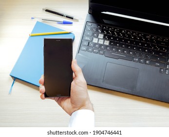 First Person View Of A Man Looking At His Mobile Phone While Working.