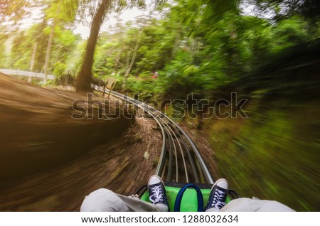 First person view of a man riding a rollercoaster cart in jungles. Motion blurred