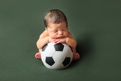 First Photo Session. Newborn Child. A Child Is Lying On A Soccer Ball