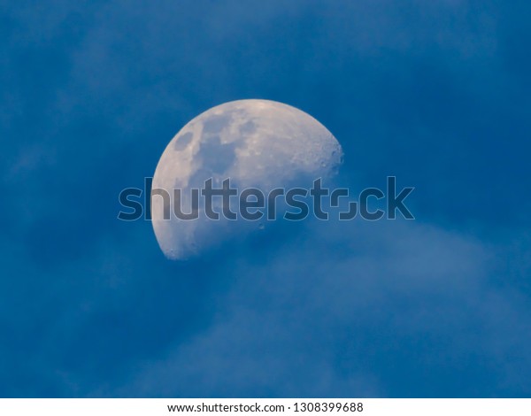First Quarter Moon with the blue color,\
framed by very fine white clouds, observed in a heavenly blue sky,\
in the southern hemisphere, sao paulo,\
Brazil