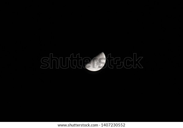 First Quarter moon\
on a jet black night sky