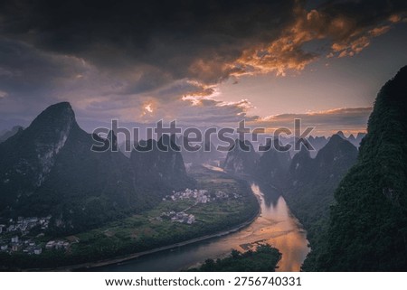 First rays of light through the clouds in Xianggong hill landscape of Guilin, Li River and Karst mountains. Xingping, Yangshuo County, Guangxi Province, China.