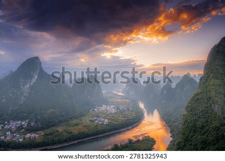 First rays of light through the clouds in Xianggong hill landscape of Guilin, Li River and Karst mountains. Xingping, Yangshuo County, Guangxi Province, China.