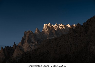 First rays of sunlight illuminating the top of the mountains in hushe valley, part of karakoram range in pakistan