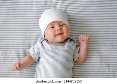 First Smile. A Cute Newborn Baby Laying On A Nappy Smiling At The First Time. Baby Care And Growing.