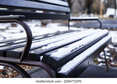 The First Snow Lies On The Park Bench At The Beginning Of Winter