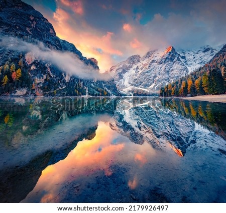 First snow on Braies Lake. Foggy autumn view of Italian Alps, Naturpark Fanes-Sennes-Prags. Picturesque sunrise in DolomiteAlps, Italy, Europe. Beauty of nature concept background.