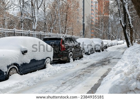 First snowfall in Moscow. White fluffy snow covered roads and cars