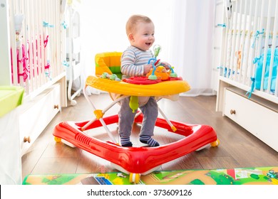 First steps of the boy in a baby walker